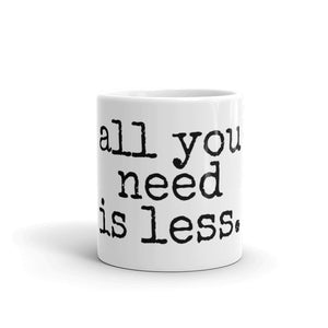 white mug with black font that says all you need is less