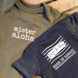 olive green and  navy blue baby boy Ivy & Co. onesie with white lettering that says mister aloha